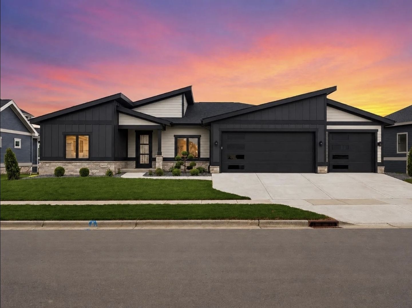 1403 Atlas Trail at sunset: charcoal and white modern ranch with a three-car garage